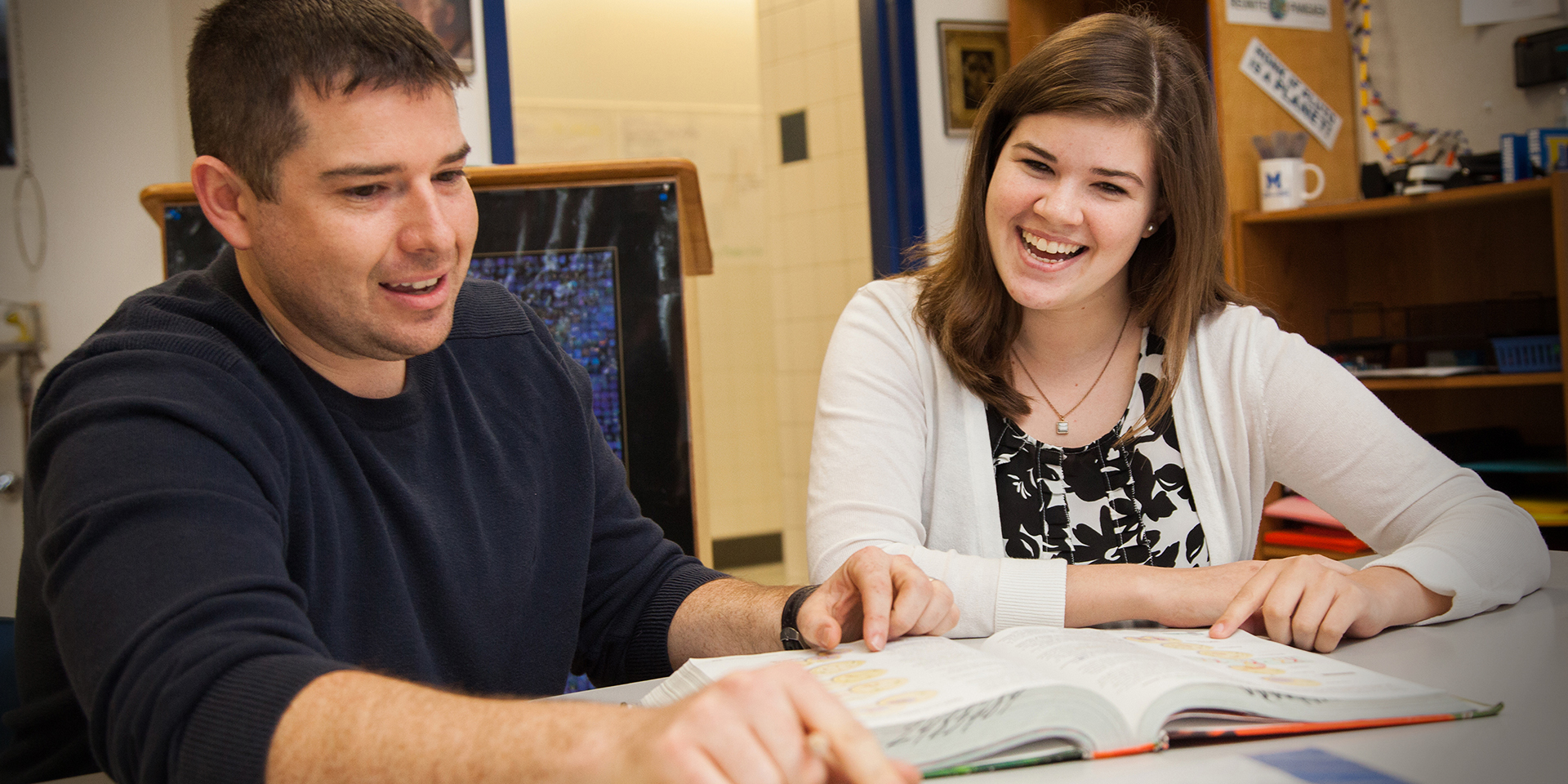 Two teachers look at a book