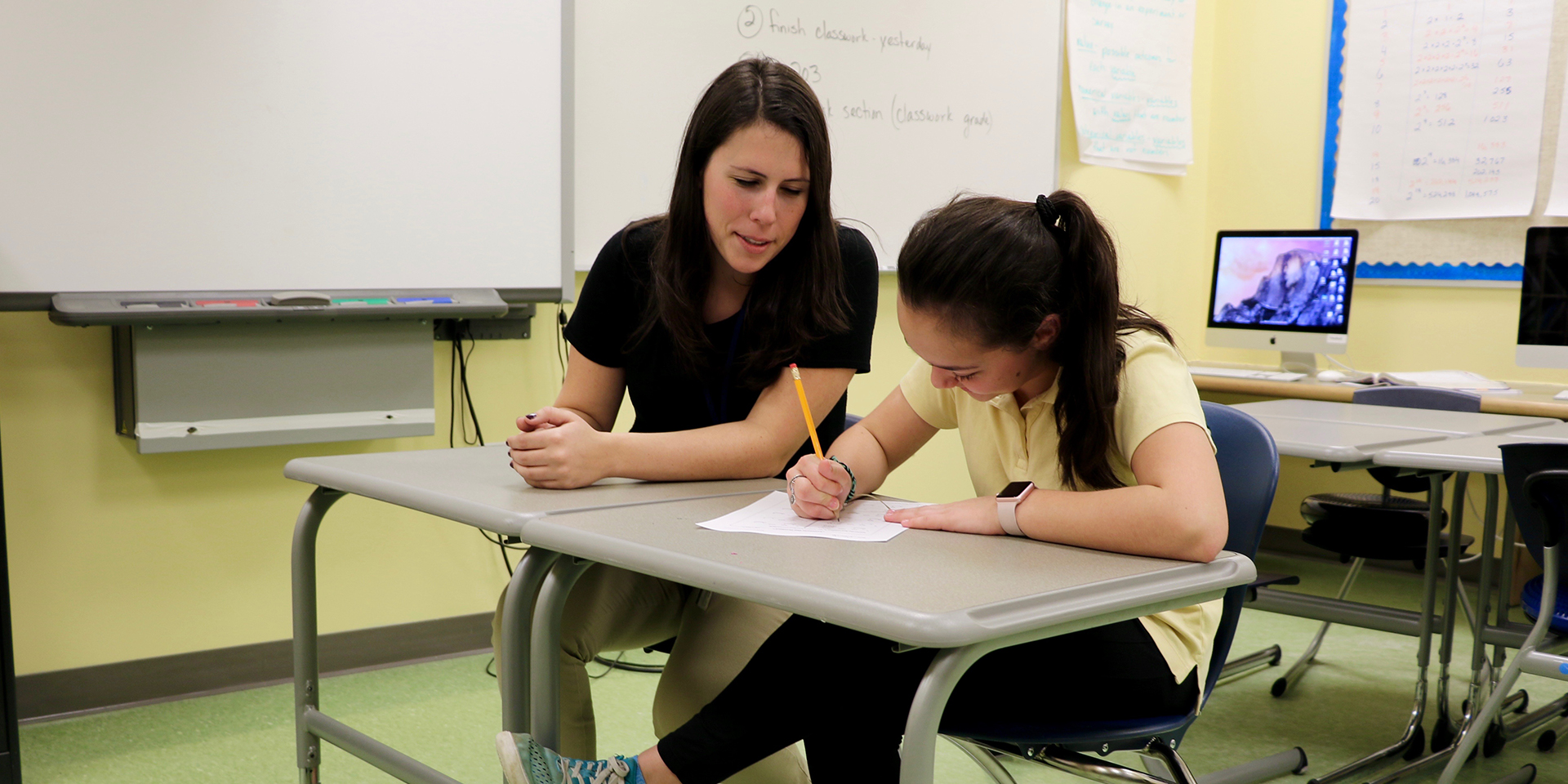 Teacher helps student with a writing assignment