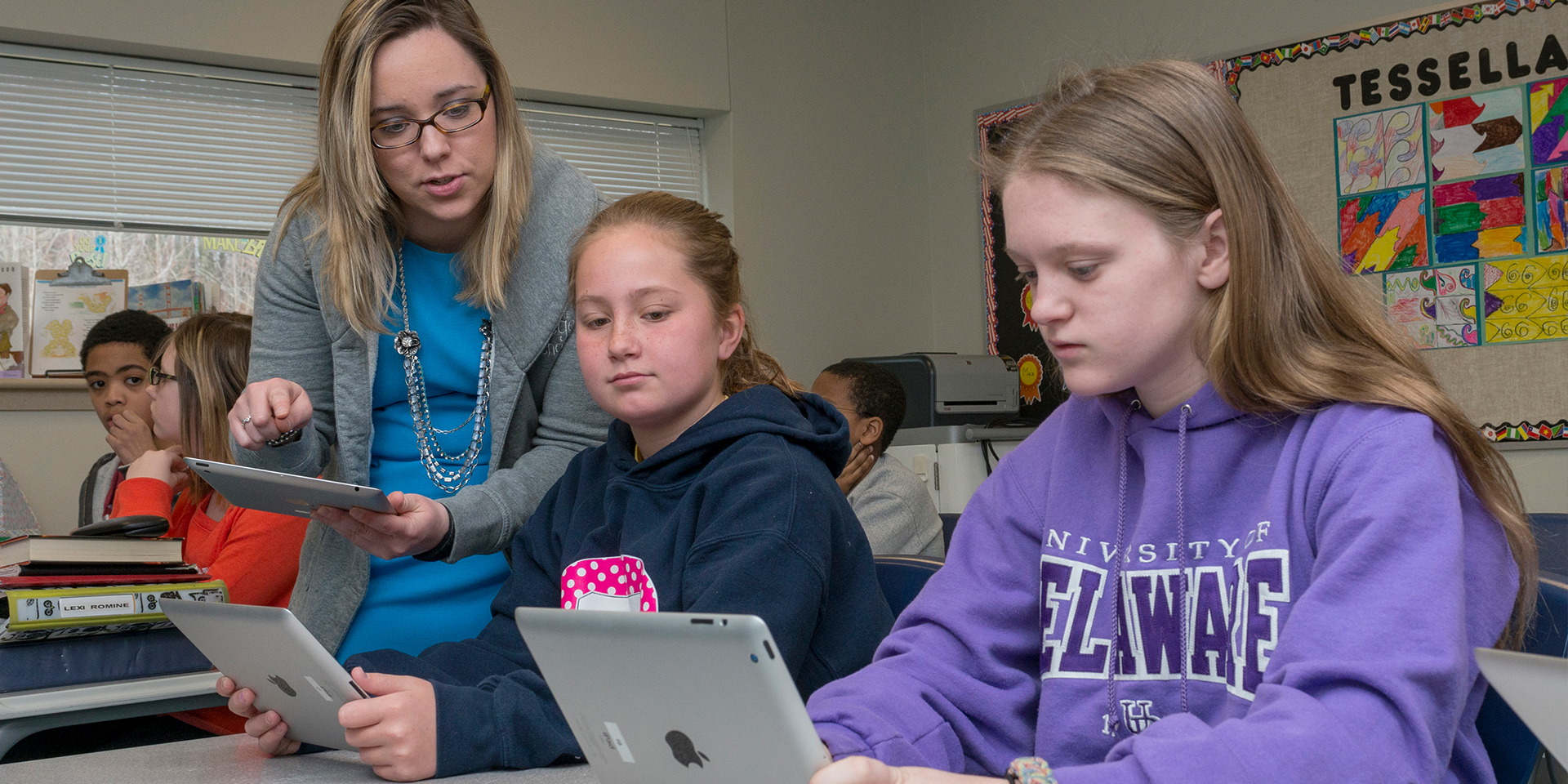 Teacher helps students with tablets